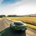 A green car parked on the side of a road