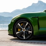 A green car parked on the side of a mountain