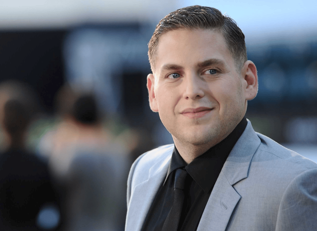 A man wearing a suit and tie smiling at the camera