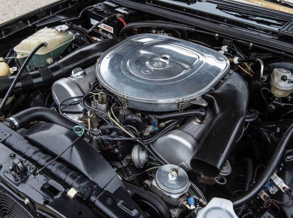 A motorcycle parked on the side of the engine of a car