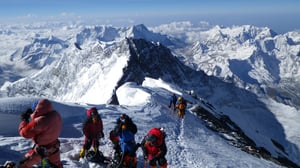 A group of people standing on top of a snow covered mountain