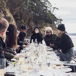 A group of people sitting at a table with wine glasses