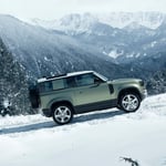 A car parked on the side of a snow covered mountain