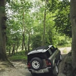 A car parked on pavement near a forest