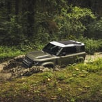 A car parked on pavement near a forest