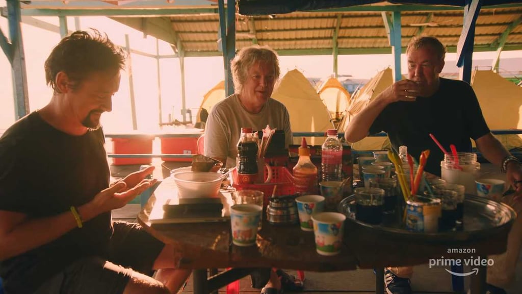 A man and woman cooking food on a table