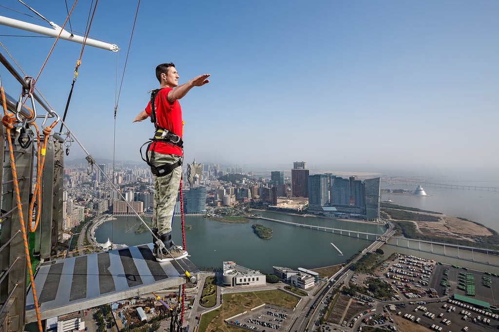 A man flying through the air while riding a skateboard on a rail