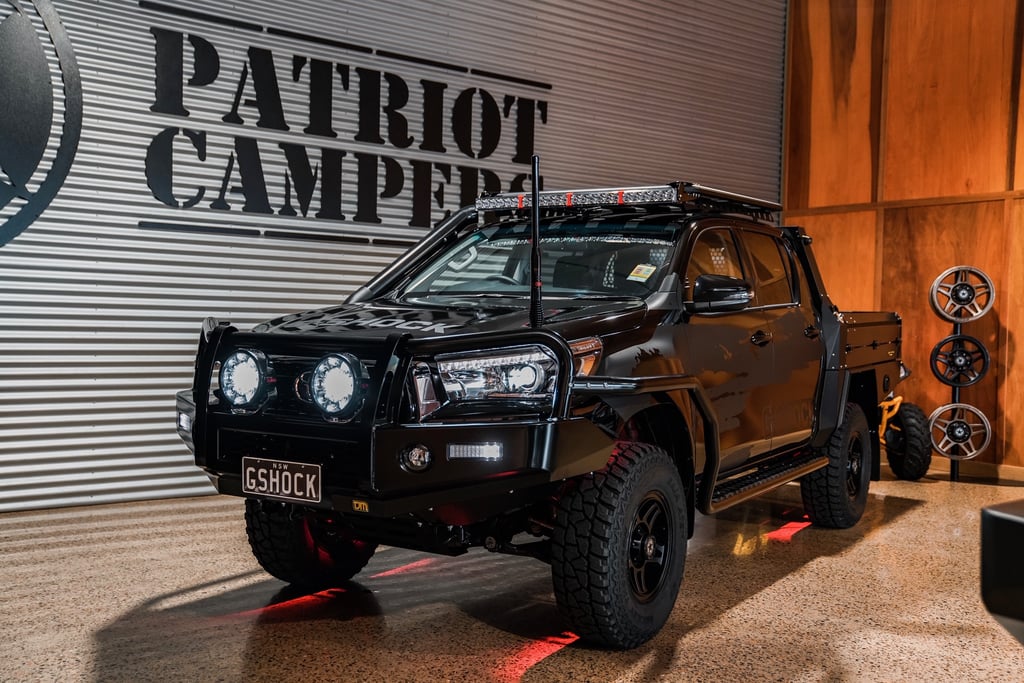 A truck is parked in front of a car