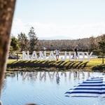 A group of people standing next to a lake