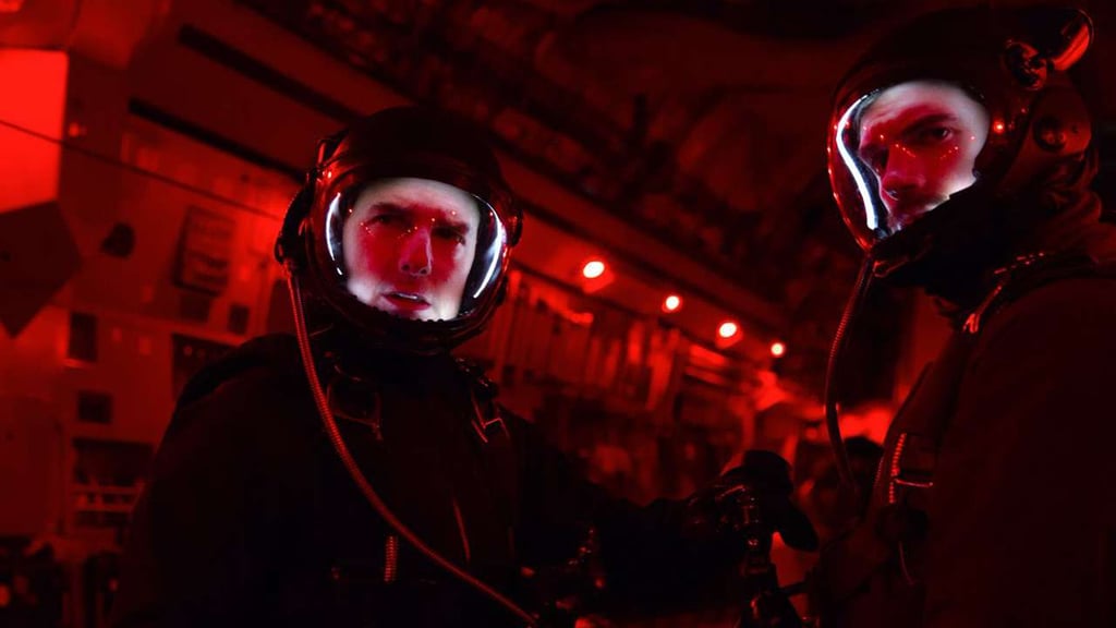 A man wearing sunglasses taking a selfie in a dark room