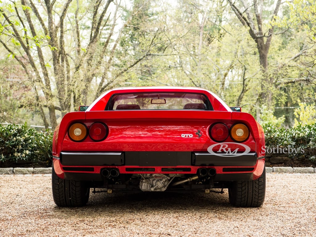 A car parked on pavement near a forest