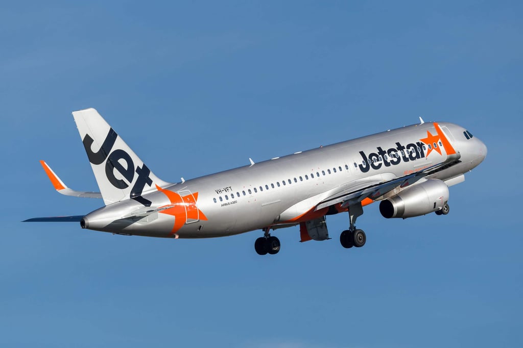 A large passenger jet flying through a blue sky