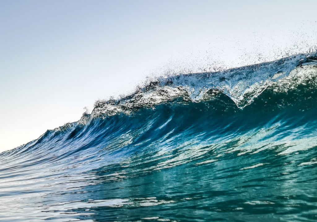 A man riding a wave on a surfboard in the ocean