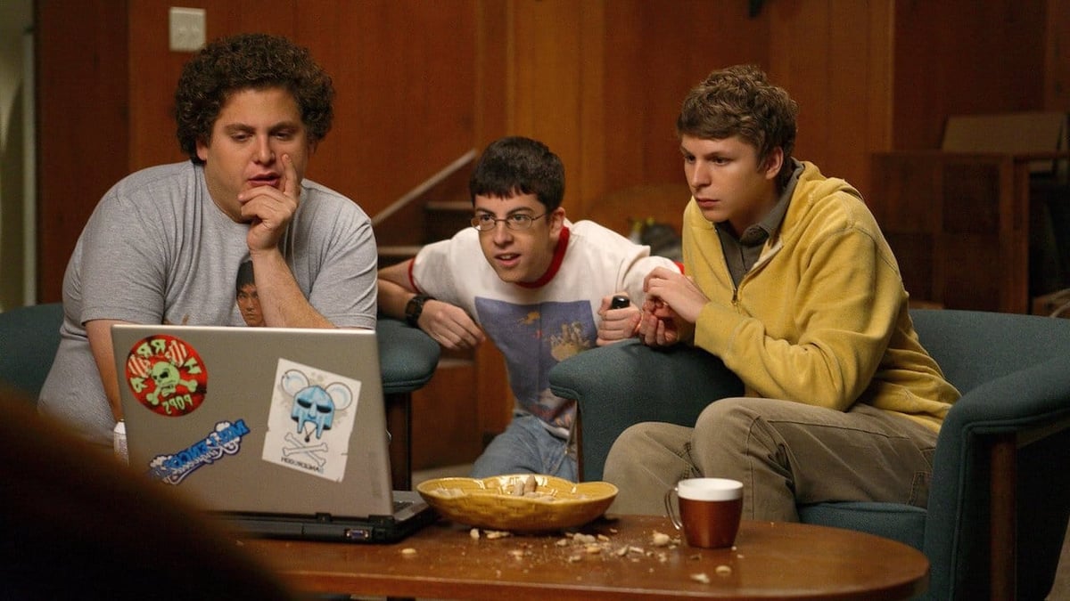 A group of people sitting at a table using a laptop