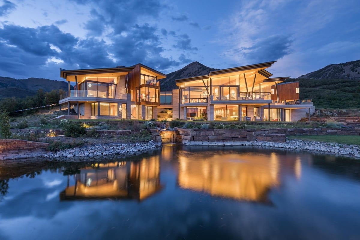 A small house in a body of water with a mountain in the background