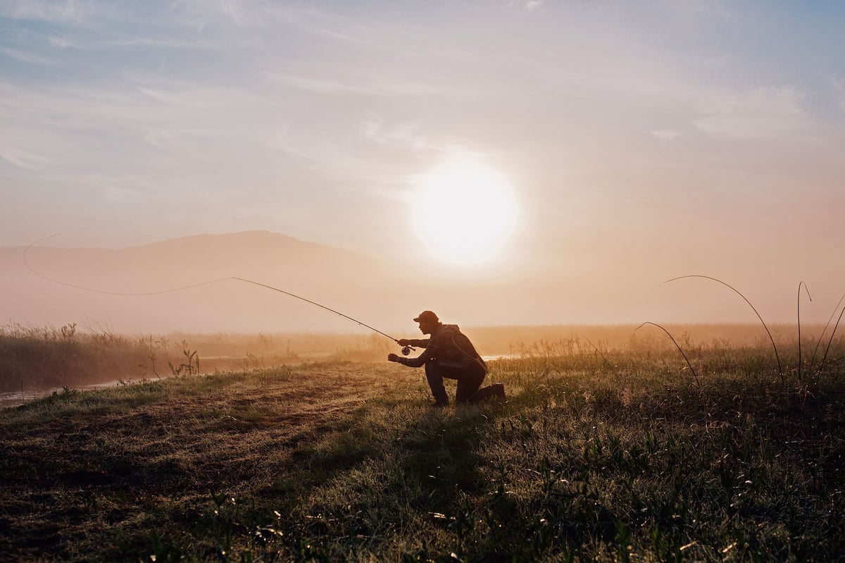 A man standing on top of a grass covered field