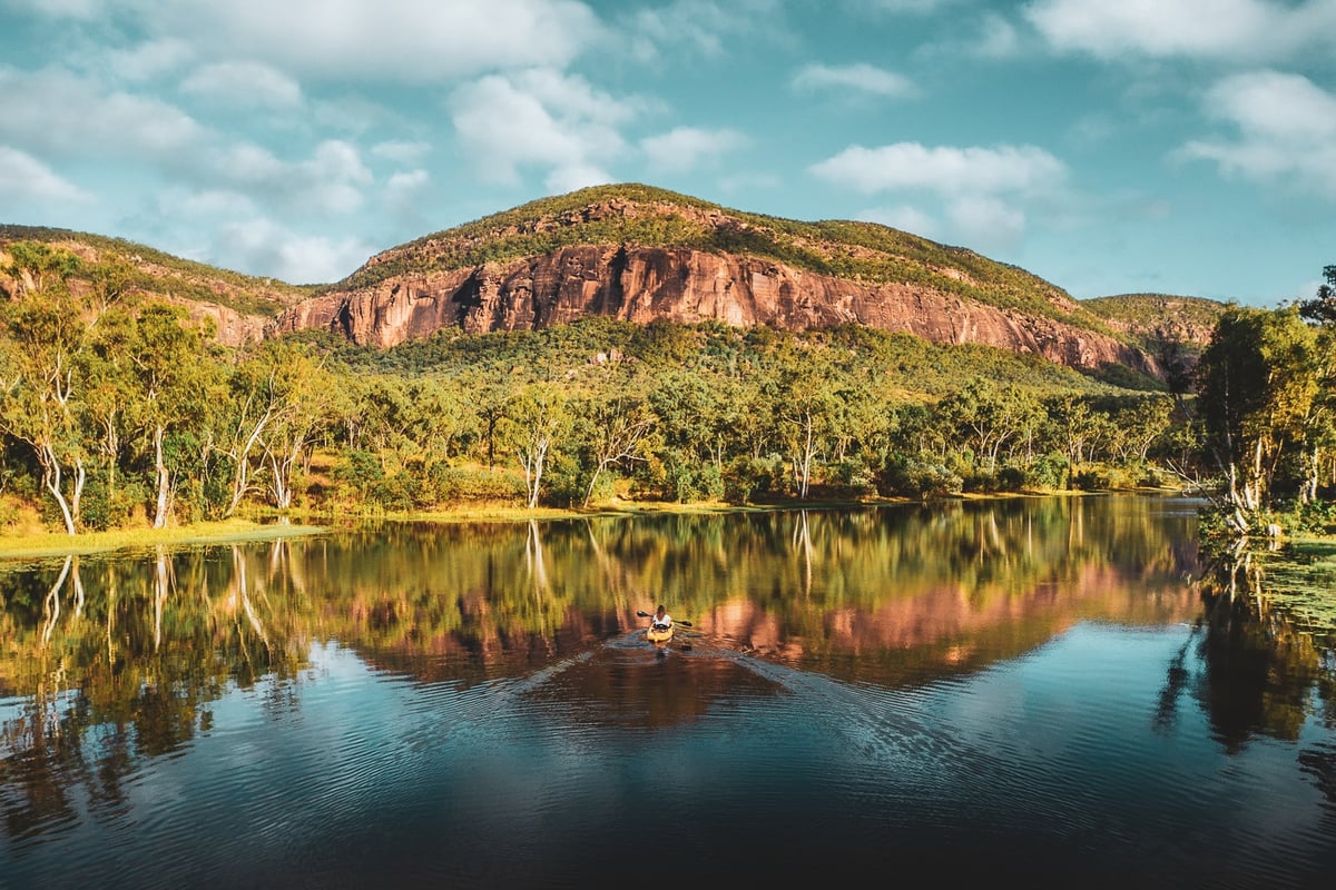 A body of water with a mountain in the background