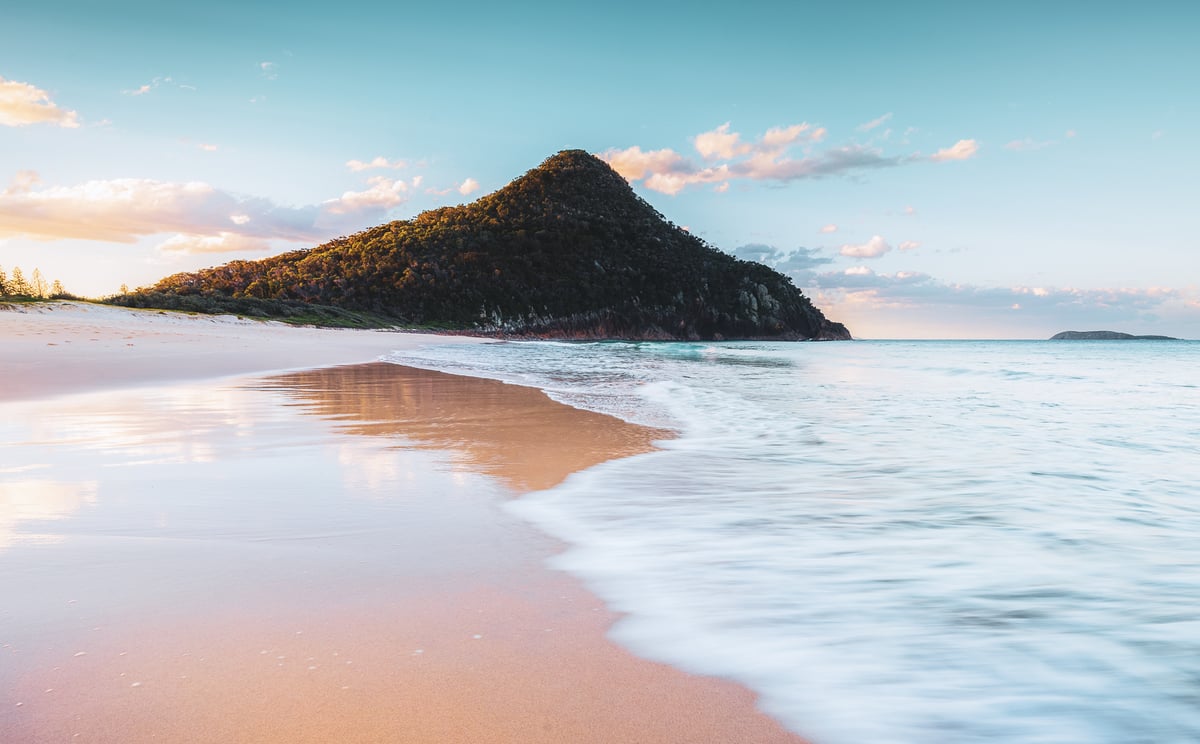 A body of water with a mountain in the background