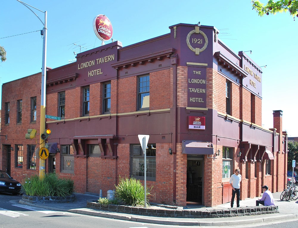 A large brick building with a clock on the side of a road