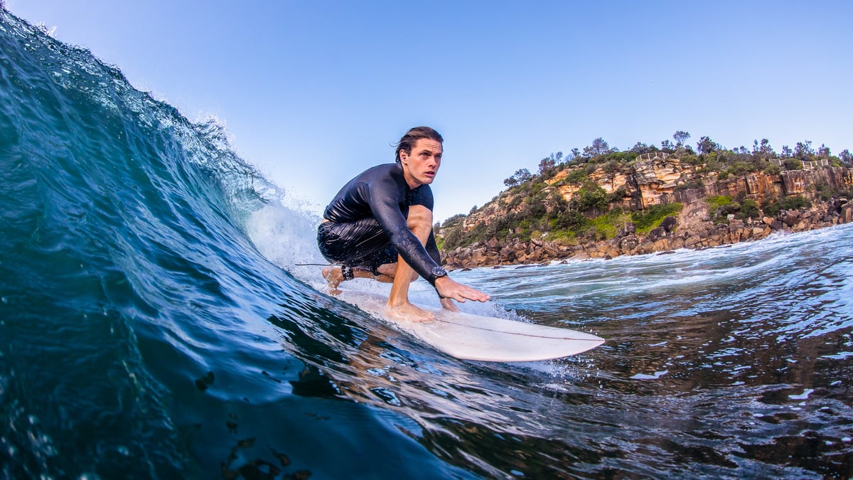 A young man riding a wave on a surfboard in the water