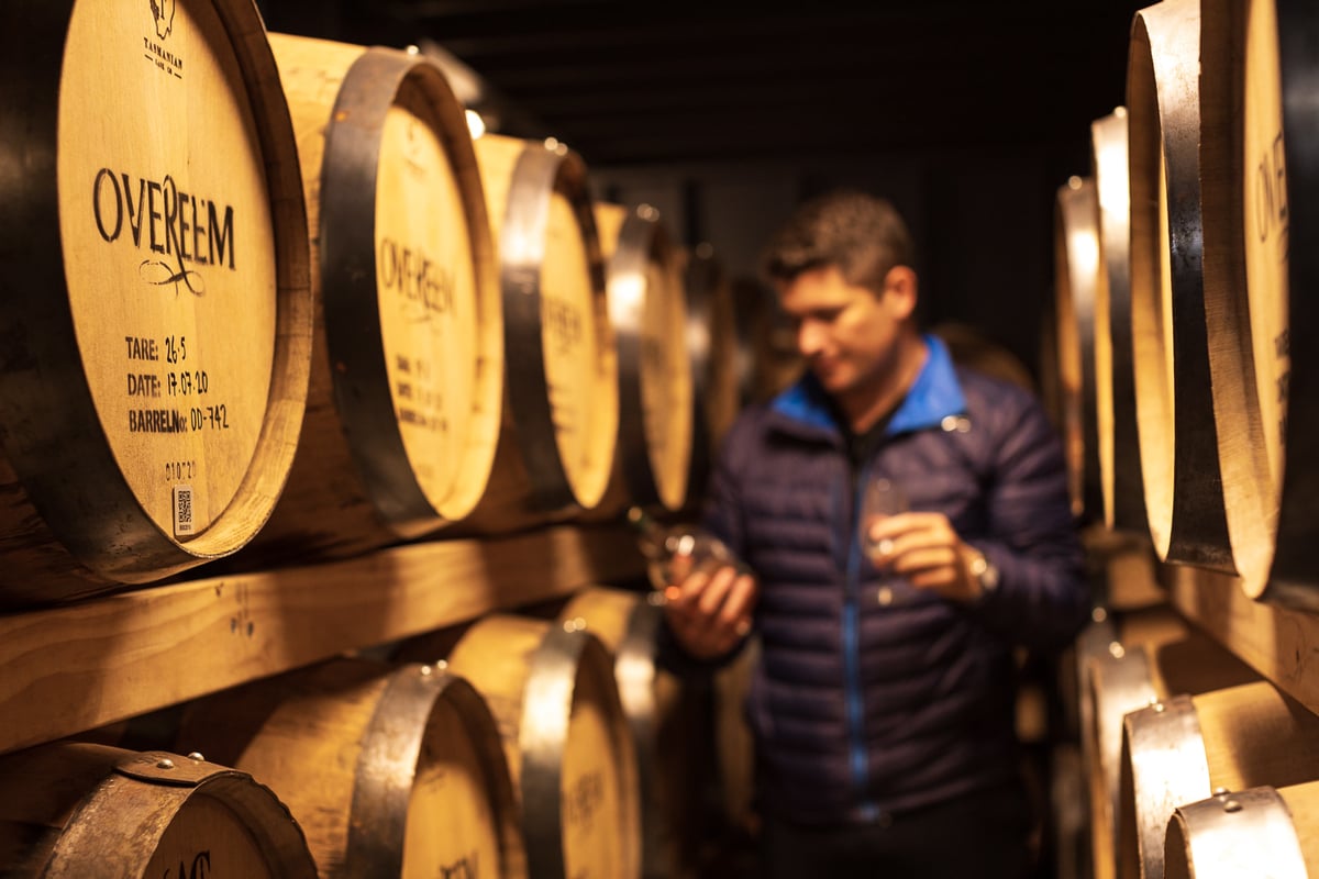 A person standing in front of a barrel