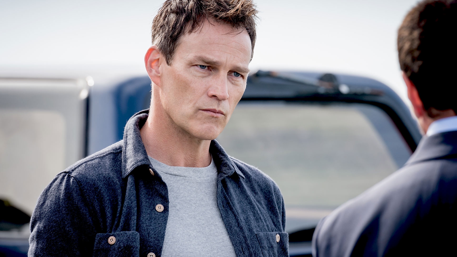 Stephen Moyer standing next to a car