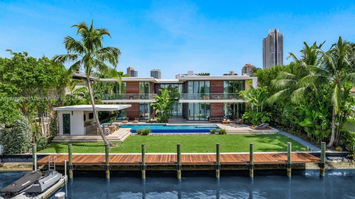 A house with a pool in front of a building