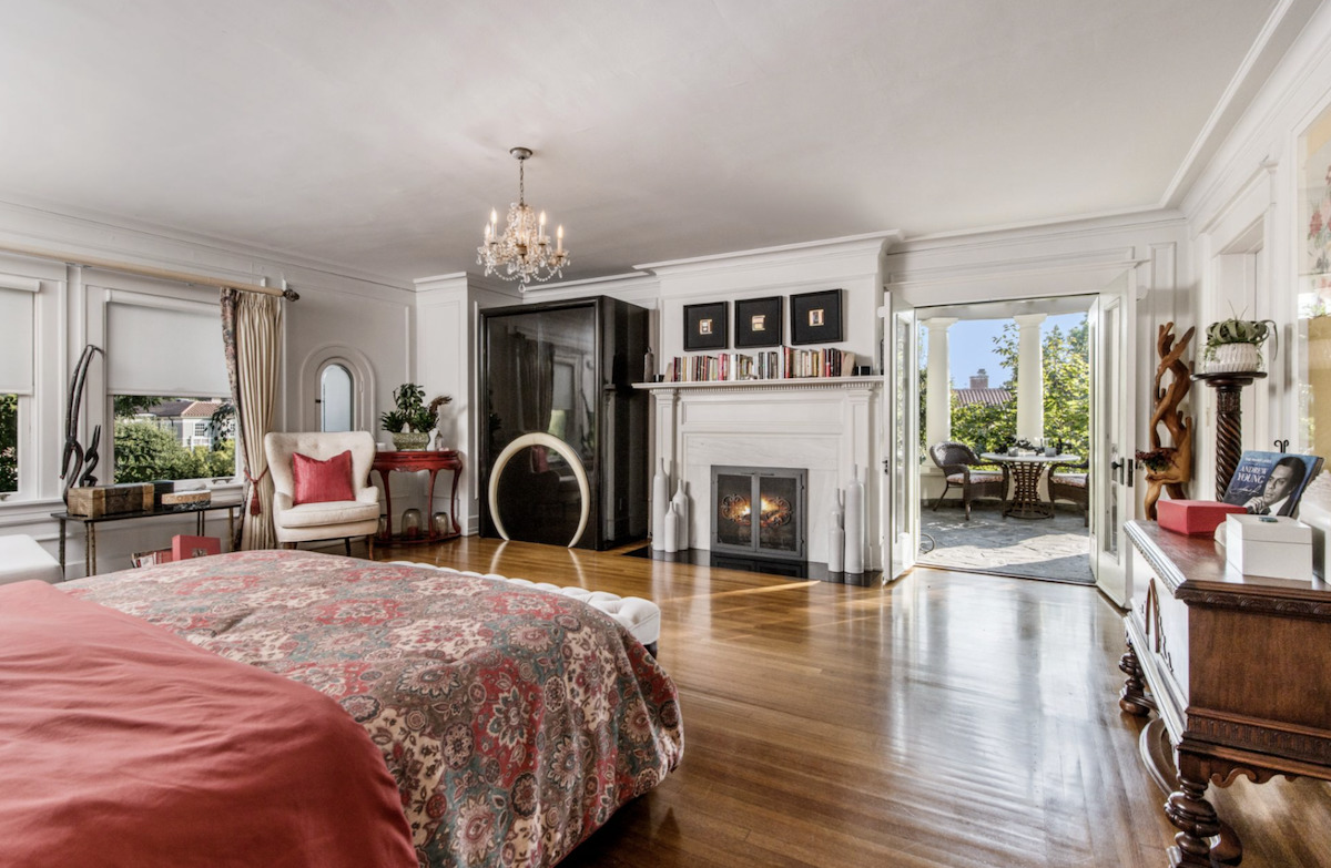 A bedroom with a bed and a chair in a room