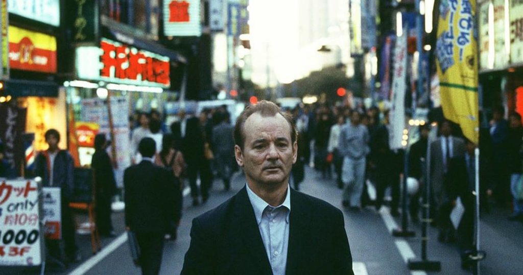 A man in a suit and tie walking on a city street