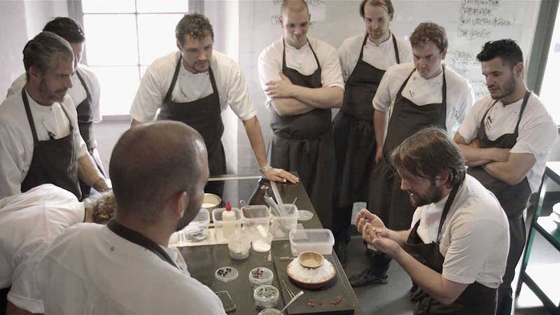 A group of people standing around a table