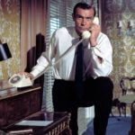A person wearing a suit and tie talking on a cell phone