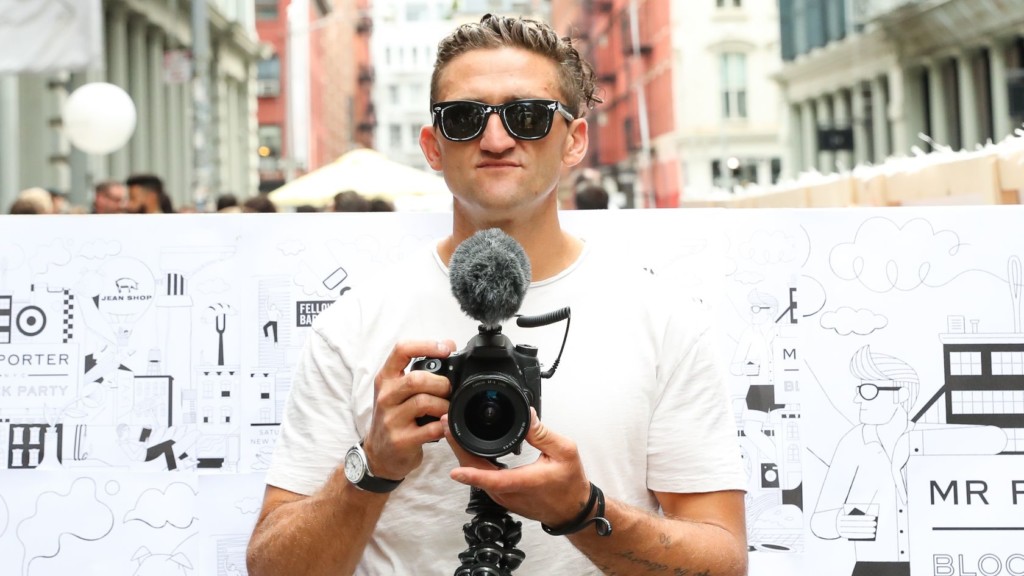 A man wearing sunglasses and standing in front of a building