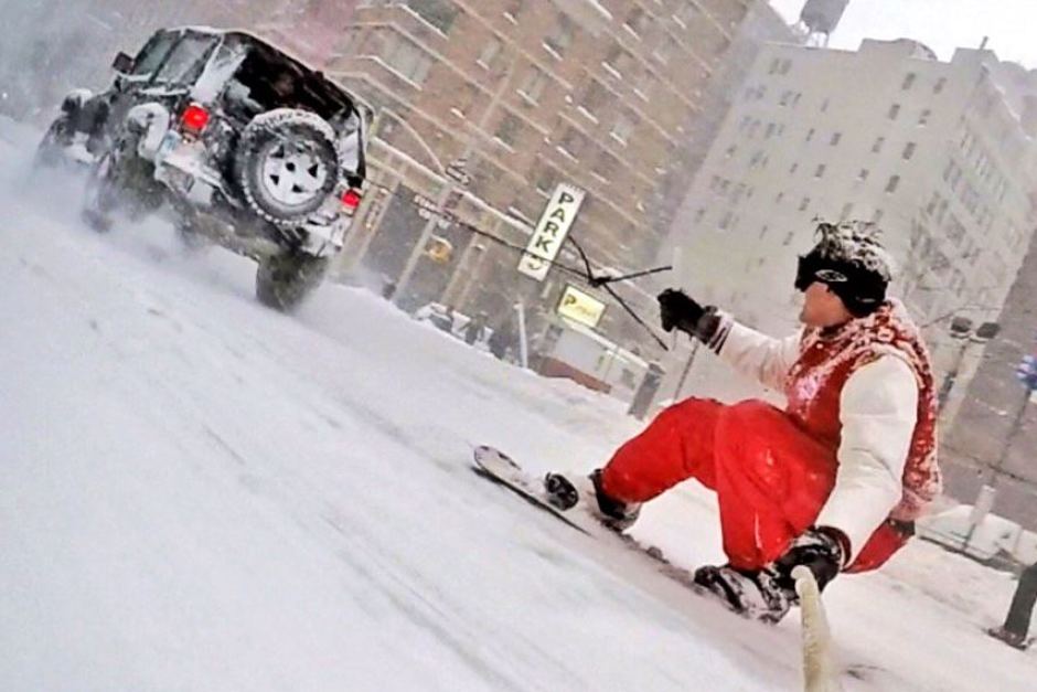 A man riding a snowboard down a snow covered slope