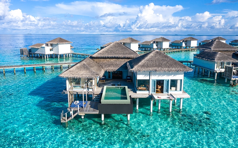 A group of lawn chairs sitting next to a pool of water