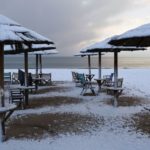 A group of lawn chairs sitting on top of a sandy beach