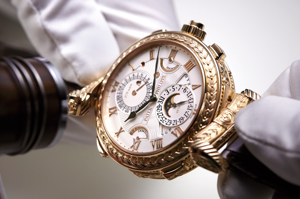 A gold clock sitting on top of a watch