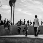 A group of people watching a man doing a trick on a skateboard