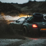 A car parked on the side of a dirt road
