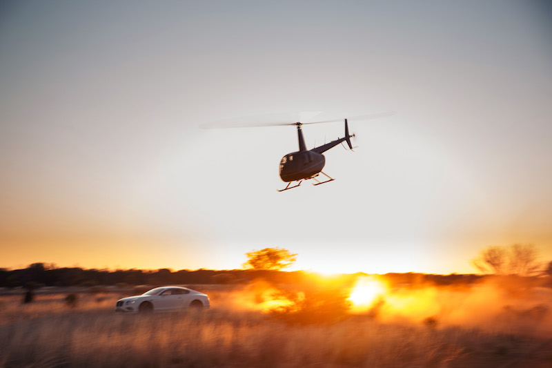 A plane flying in the air with a sunset in the background