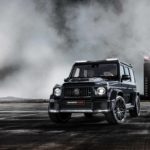 A steam engine driving down a dirt road