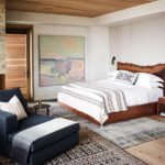 A bedroom with a bed and desk in a room