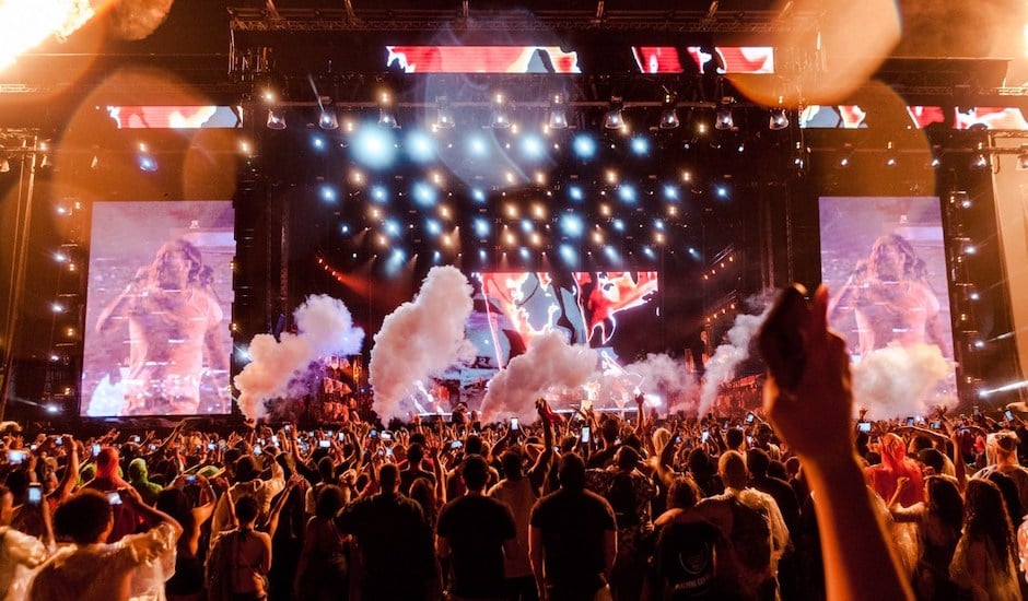 A group of people watching a band on stage in front of a crowd