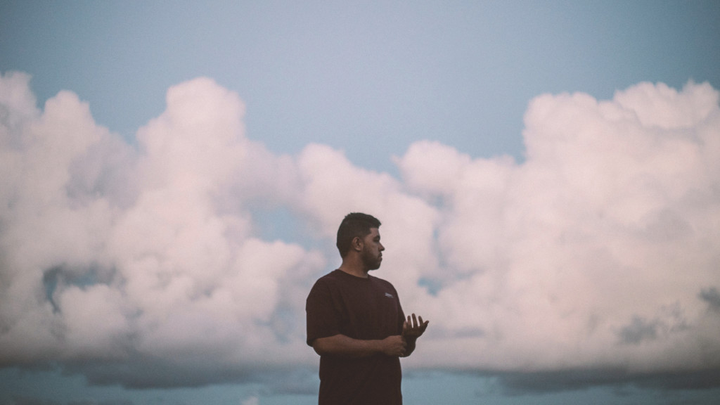 A man standing in front of a cloudy sky