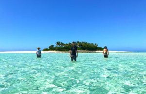 A group of people standing next to a body of water