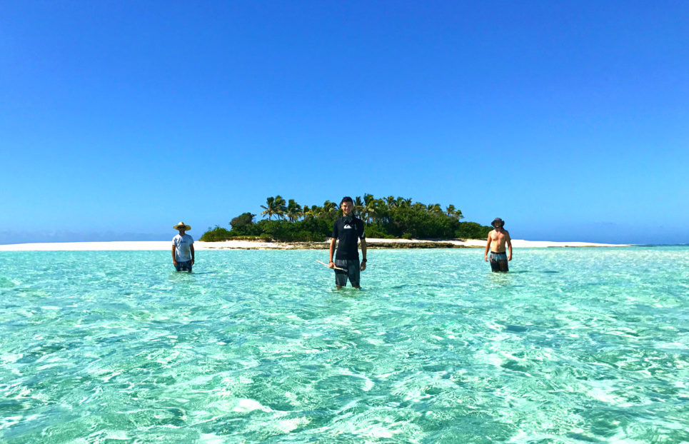 A group of people standing next to a body of water