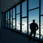 A man standing next to a window