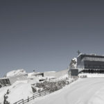 A group of people riding skis across snow covered ground