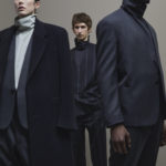 A group of people standing next to a man wearing a suit and tie