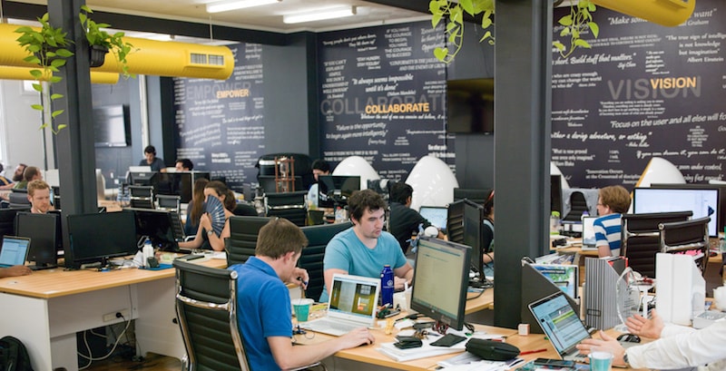 A group of people sitting at a desk in front of a computer