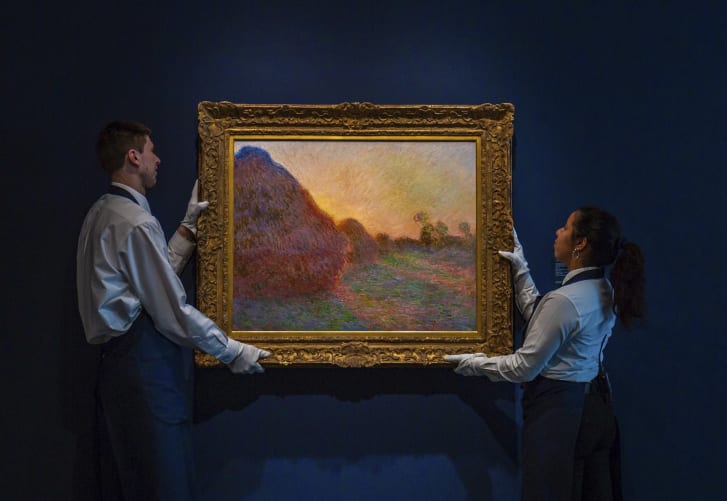 A man and a woman standing in front of a painting